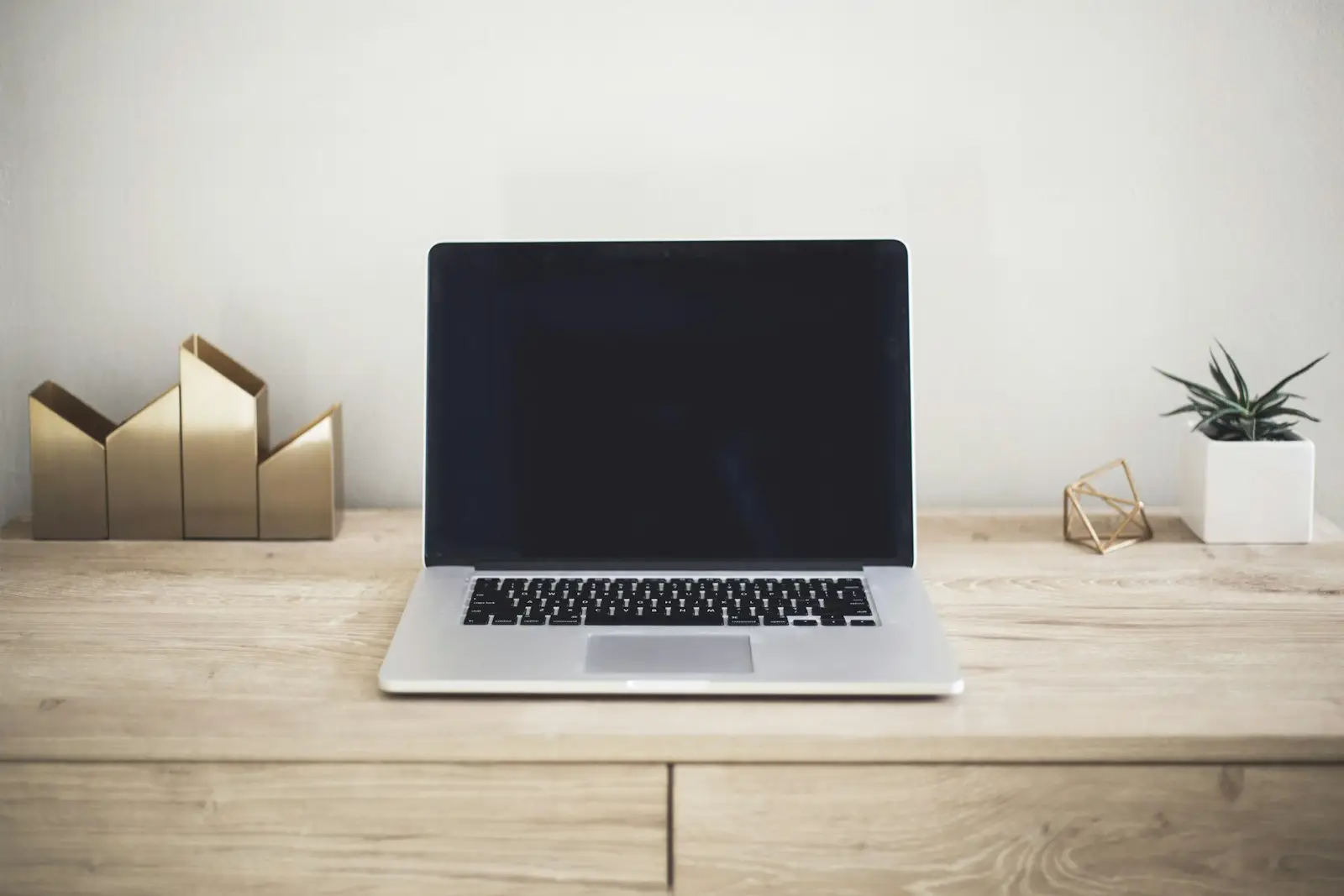 A laptop open on a wooden desk