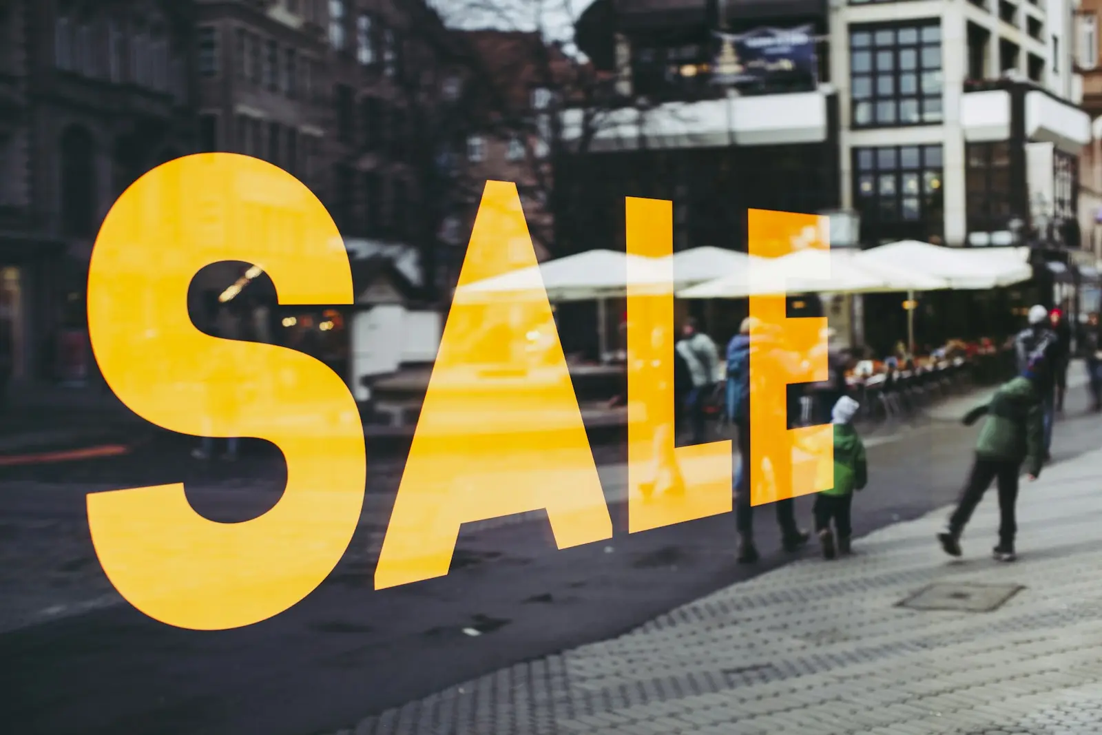 A yellow SALE sign in a shop window