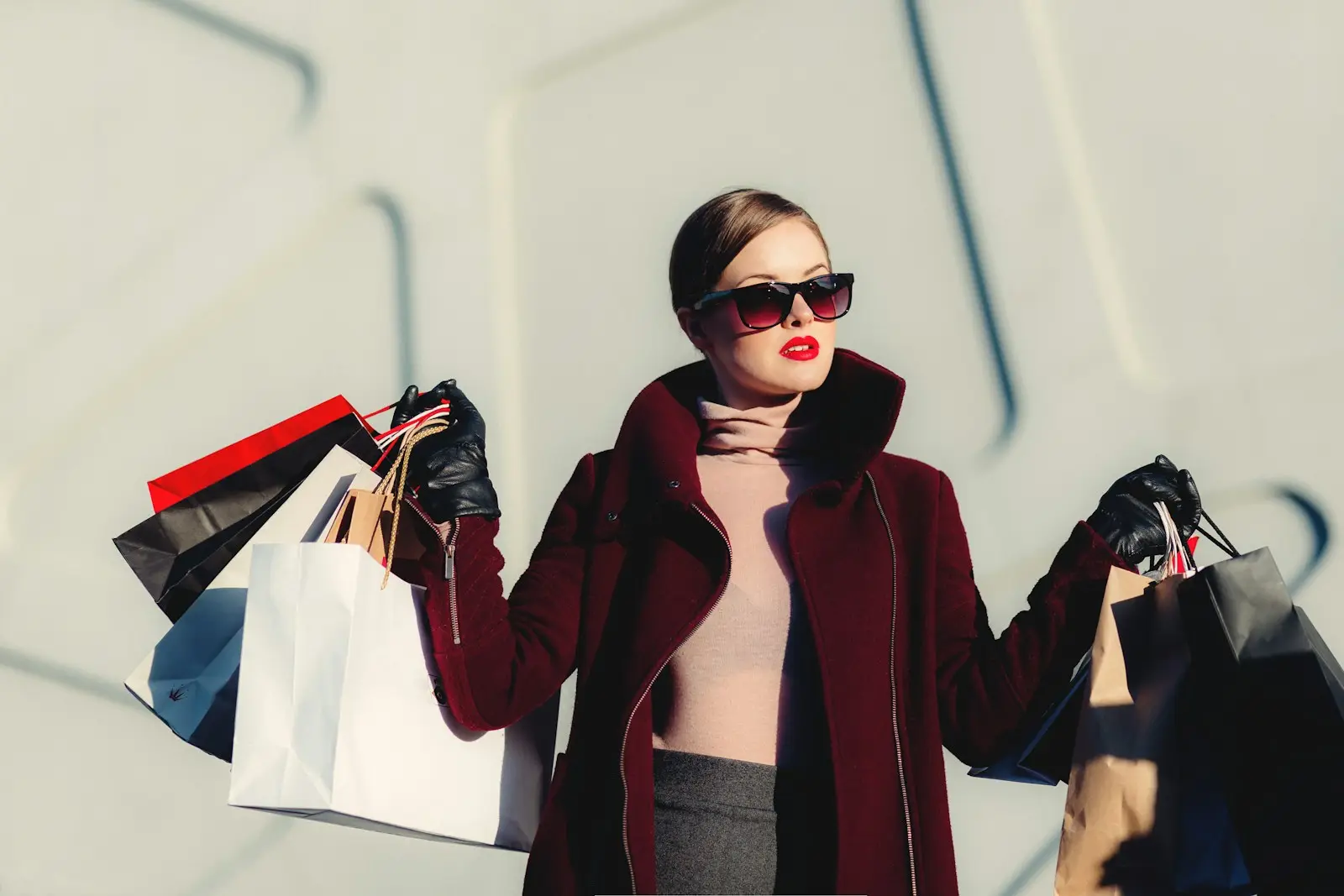 A shopper holding several paper shopping bags